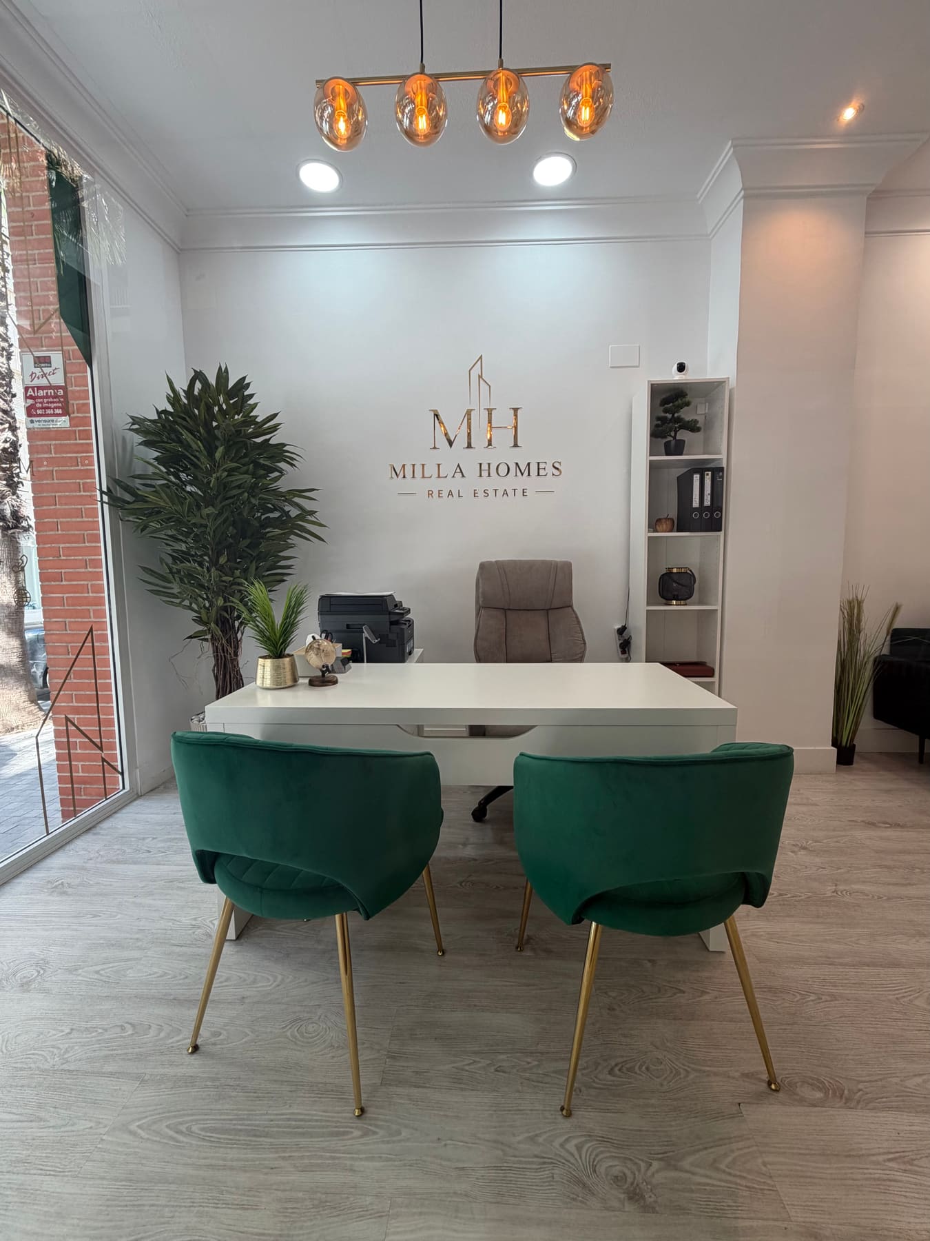 Front desk of the Milla Homes office with the Milla Homes Real Estate logo